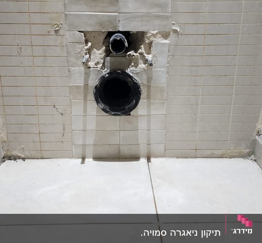 צינור ביוב בקיר עם אריחים שבורים